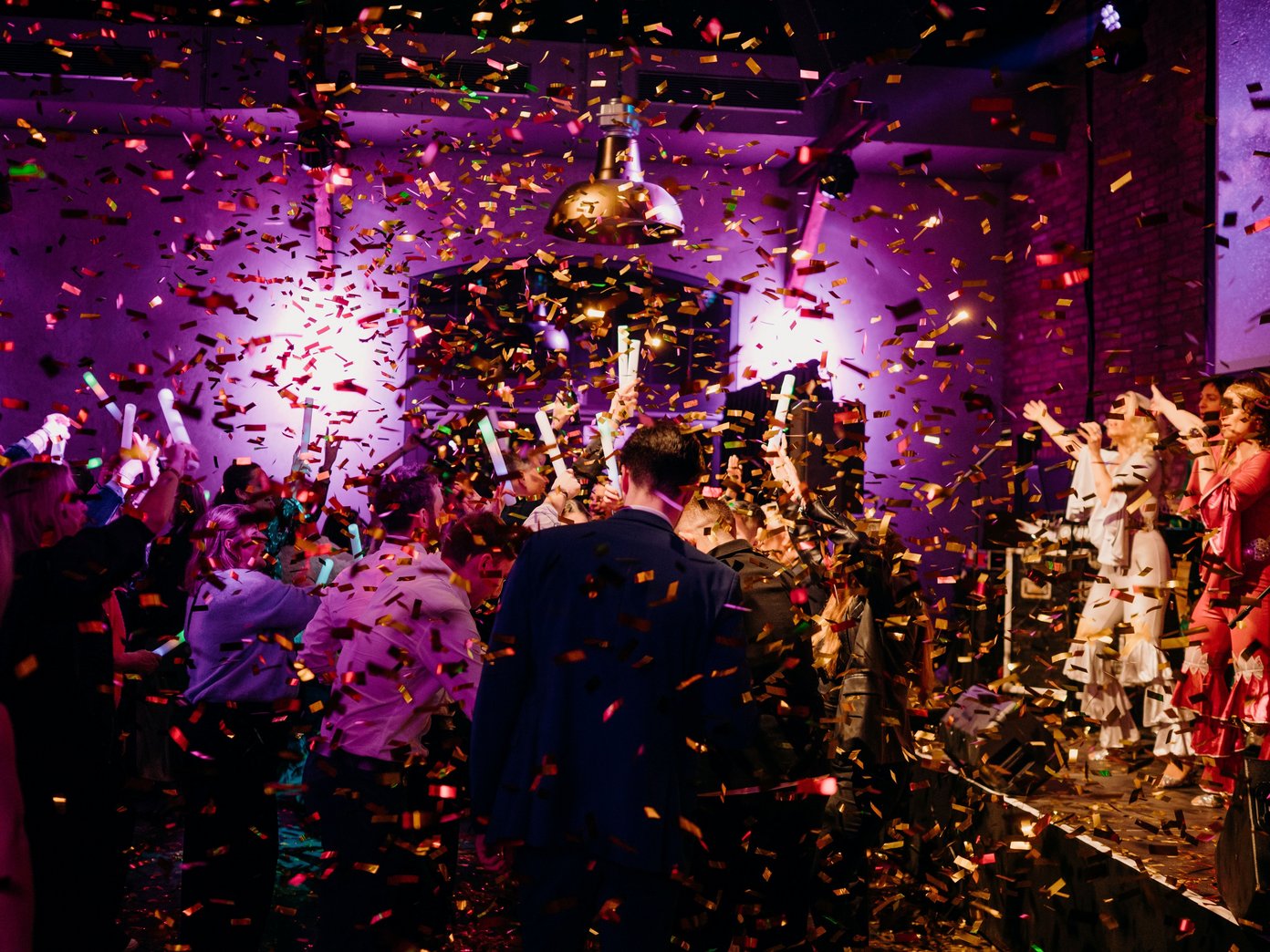 Goldener Konfettiregen auf viele tanzende Menschen